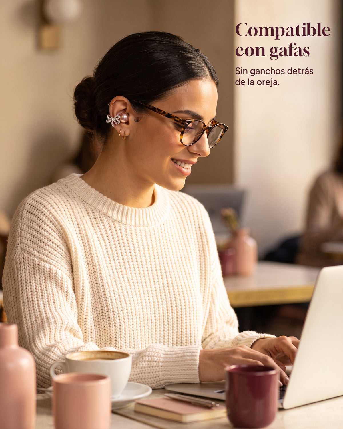 Woman with glasses working in a café wearing Nacary earbuds